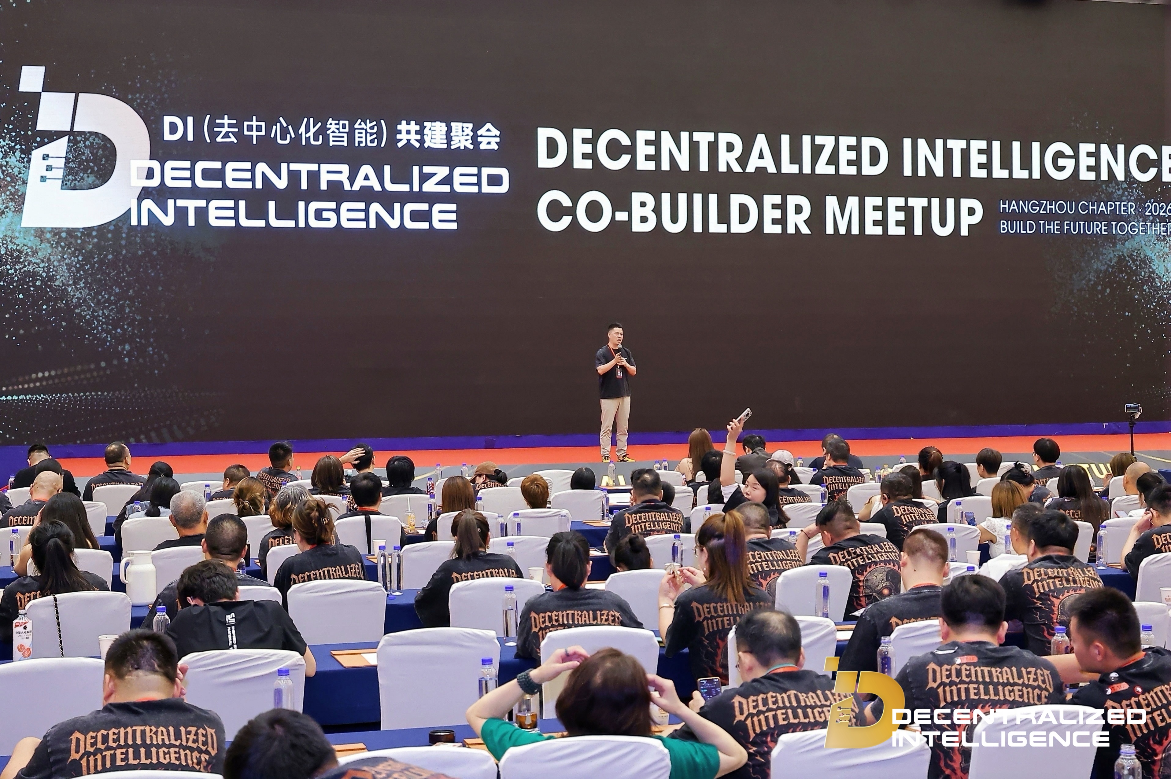 A speaker addressing attendees from the DI Co-Builder Meetup stage.